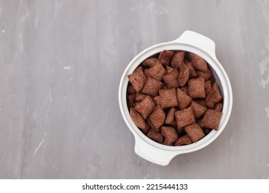 Chocolate Cereals In Small White Bowl On Gray Ceramic