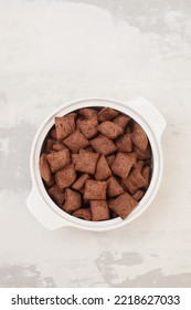 Chocolate Cereals In Small White Bowl On Gray Ceramic