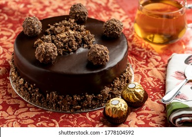 Chocolate Cheese Cake On A Red Table Mat, Topped With Chocolate Balls