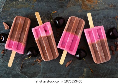 Chocolate And Cherry Ice Pops. Above View In A Row Over A Dark Slate Background.