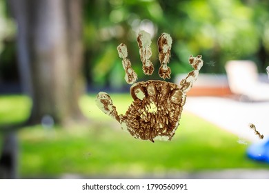 Chocolate Child Hand Print On Glass Door Window Outdoor Yard In The Background