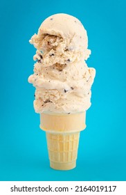 Chocolate Chip Cookie Dough Ice Cream Cone Isolated On A Blue Background