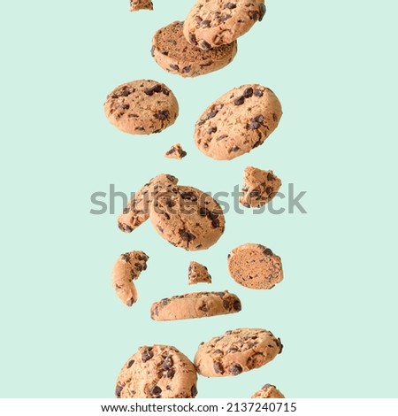 Chocolate chip cookie floating on a green background. Aesthetic sweet food concept. Flying chocolate biscuits	