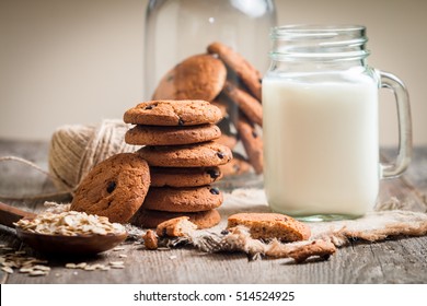 Chocolate chip cookies with milk on burlap and rustic wooden table - Powered by Shutterstock