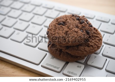 Chocolate chip cookies on keyboard computer background copy space. Cookies website internet homepage policy accepted or blocks concept.