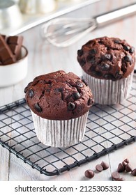 Chocolate chip muffins on a white kitchen set and utensils with selected focus