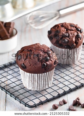 Chocolate chip muffins on a white kitchen set and utensils with selected focus