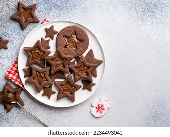 Chocolate christmas cookies (linzer cookies star shaped) with chocolate spread (melted). Delicious christmas dessert, festive baking. New year background. Top view. Copy space. - Powered by Shutterstock