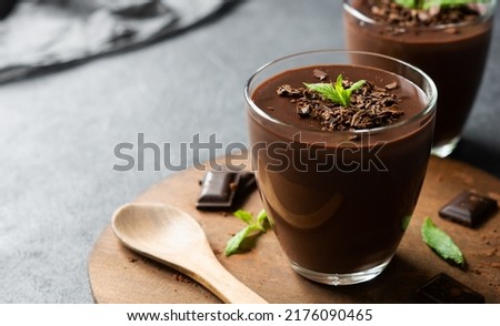 Chocolate cocoa pudding, mousse in glass cup on rustic table, supangle