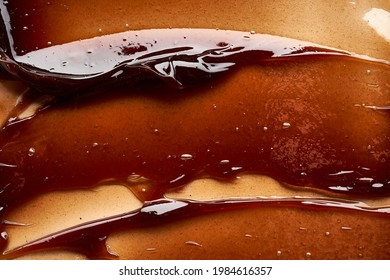 Chocolate Colored Gel Smear And Texture. Cosmetic Gel Or Caramel Syrup On White Background