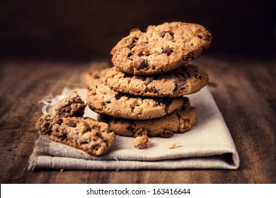 Chocolate cookies on white linen napkin on wooden table. Chocolate chip cookies shot on coffee colored cloth, closeup. - Powered by Shutterstock