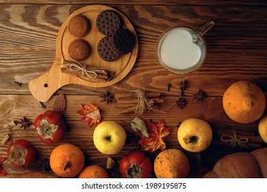 Chocolate Cookies, Vegetables, Fruit And Milk In A Mug In The Shape Of A Heart. Baking With Cinnamon Sticks On A Wooden Background. Autumn Composition. Apples And Persimmons, Fall Harvest. 