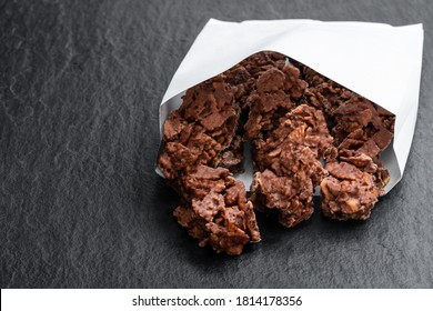 Chocolate  corn flake clusters in paper bag on black stone background  - Powered by Shutterstock