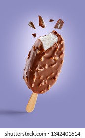 Chocolate Covered Ice Cream With Nuts On A Purple Background  Bitten On Top With Chocolate Bits. Taste Explosion