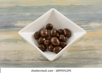 Chocolate Covered Peanuts Candy In White Candy Dish On Table