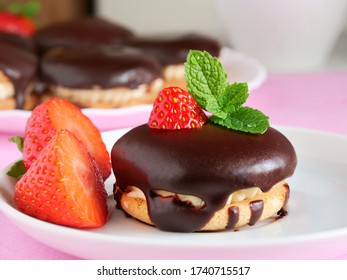 Chocolate covered sandwich cookies with vanilla cream and strawberries