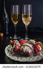 Chocolate Covered Strawberries and Pineberries with Champagne: Candied berries with flute glasses and a champagne bottle in the background
