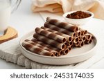 Chocolate cream flavour wafers sticks or wafer rolls in white plate.snack food.