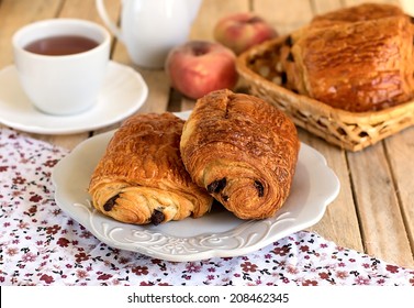 Chocolate croissants (pain au chocolat) with tea for breakfast. Selective focus - Shutterstock ID 208462345