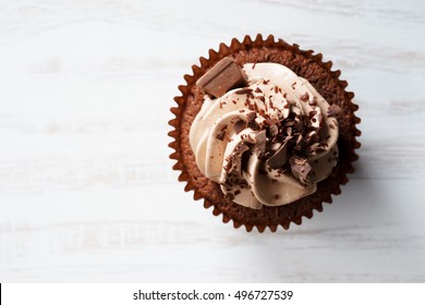 Chocolate Cupcake With Chocolate Butter Cream Swirl On White Wooden Background, Top View