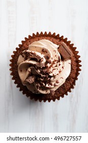 Chocolate Cupcake With Chocolate Butter Cream Swirl On White Wooden Background, Top View