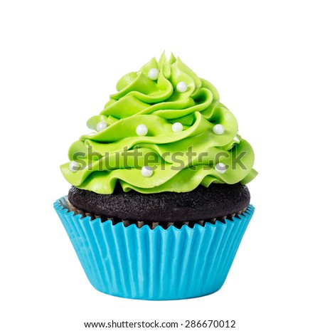 Chocolate cupcake decorated with green icing and sprinkles isolated on white