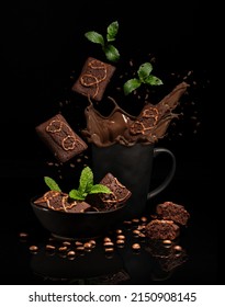 chocolate cupcakes lying in a black dish, flying cupcakes, a splash of liquid chocolate in a cup with mint leaves, on a black background with reflection - Shutterstock ID 2150908145