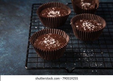 chocolate cups with salted caramel and nuts, dark blue background, selective focus - Powered by Shutterstock