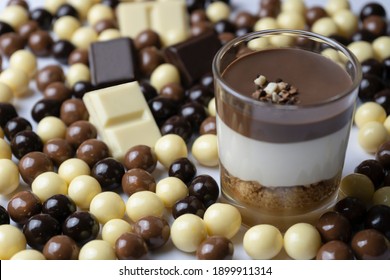 Chocolate dessert in glass (yogurt or cream, cookies and nuts )with chocolate balls (black chocolate, milk and white chocolate ).