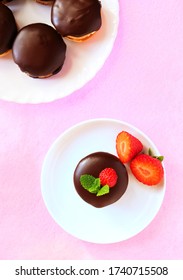 Chocolate dipped sandwich cookies with strawberries on white plate, vertical, top view, flat lay