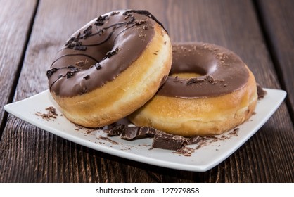 Chocolate Donuts on a plate on wooden background - Powered by Shutterstock