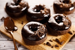 Chocolate Donuts With Chocolate Pieces Topping On Wooden Table Background.