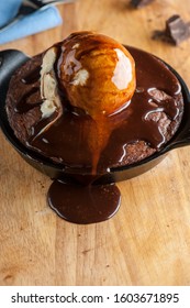 Chocolate Double Fudge Brownie, Ala Mode.  Homemade Brownie Topped With Vanilla Bean Ice Cream, Chocolate And Hot Chocolate Syrup. Action Shot.