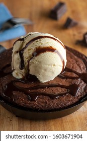 Chocolate Double Fudge Brownie, Ala Mode.  Homemade Brownie Topped With Vanilla Bean Ice Cream, Chocolate And Hot Chocolate Syrup. Action Shot.