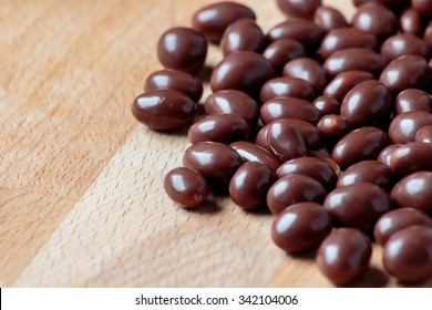 Chocolate dragee on wooden background