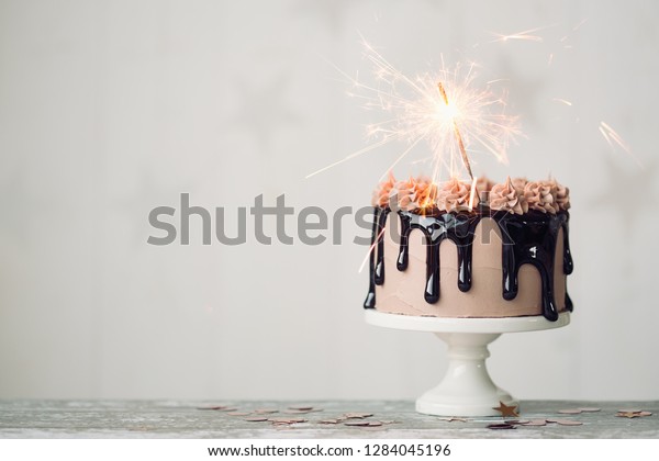 Chocolate drip cake with sparkler for a\
birthday or\
celebration