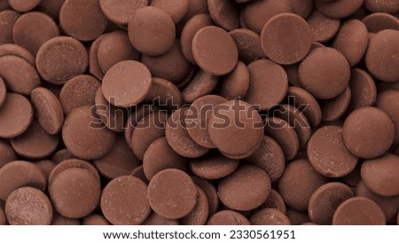 chocolate drops, delicious dark chocolate chips, chocolate galettes, background. selective focus.