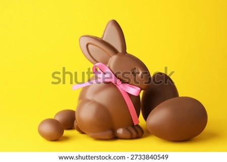 Chocolate Easter bunny and eggs on yellow background