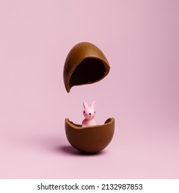 Chocolate Easter egg broken in half with cute bunny on pastel pink background with creative copy space. Minimal Easter holiday concept. Advertisement or sale banner idea. - Powered by Shutterstock