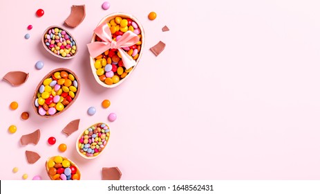 Chocolate Easter Eggs And Candy On Pink Table, Festive Easter Frame Flat Lay, Copy Space. Easter Card With Traditional Sweet Treats On Pastel Table Top. Sweet Easter Concept