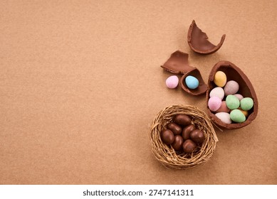 Chocolate easter eggs and candy scattered on brown background