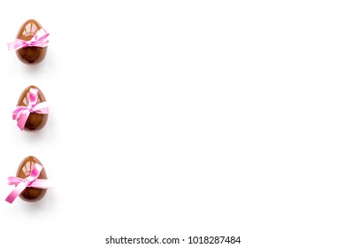 Chocolate Easter eggs on white background top view copy space