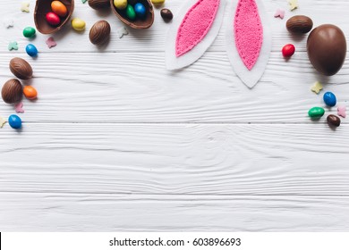 Chocolate Easter Eggs On White Wooden Background.