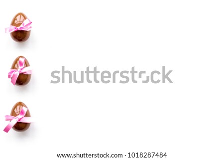 Chocolate Easter eggs on white background top view copy space