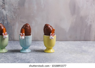 Chocolate easter eggs over grey background in nest
