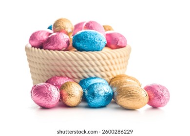 Chocolate easter eggs wrapped in multi colored foil in bowl isolated on a white background.