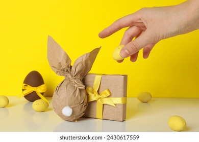 A chocolate egg in a wrapper and with a gift