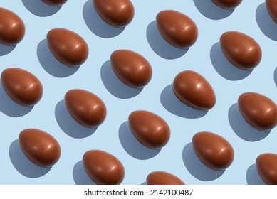 Chocolate eggs. Easter eggs. Seamless pattern of whole chocolate eggs on a blue background. Easter sweet chocolate background - Powered by Shutterstock