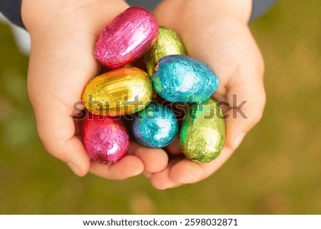 Chocolate eggs in foil Easter bright decor. Eggs in the hands of a child Easter eggs.