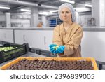 Chocolate factory woman worker work on production line with sweets candy. Concept control food industry.
